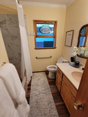 a bathroom with a sink and a toilet and a window at Extremely Chill 3 Bedroom Home in Long Beach