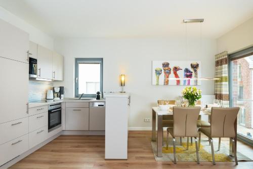 a kitchen and dining room with a table and chairs at Ostsee - Appartement Nr 89 "Salzaster" im Strand Resort in Heiligenhafen