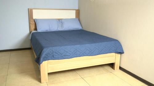 a small bed in a room with a blue bedspread at hostal confort Iztapalapa hospedaje económico y cómodo en cdmx in Mexico City