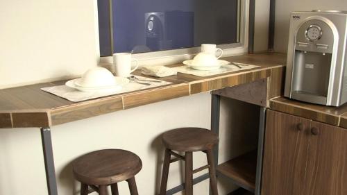 a bathroom with a counter with two stools and a mirror at hostal confort Iztapalapa hospedaje económico y cómodo en cdmx in Mexico City