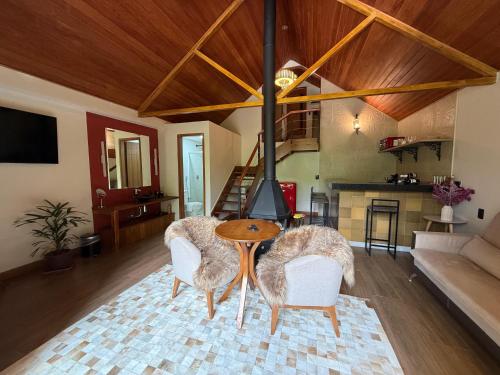 ein Wohnzimmer mit einem Tisch und einigen Stühlen in der Unterkunft Chalés Princesa Isabel in Petrópolis