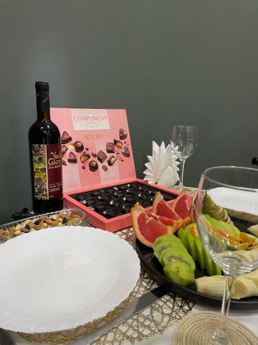 a table with a bottle of wine and a plate of fruit at RUNO inn Hotel in Baku