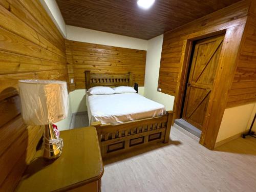 a bedroom with a bed and a table with a lamp at Alto de la Castilla in Constanza