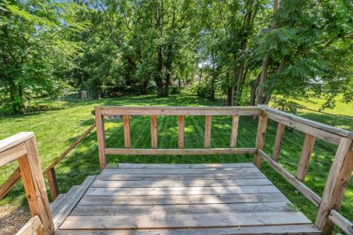 a wooden bench sitting in a field with trees at SMART Home close to downtown, MSU, and more in Springfield