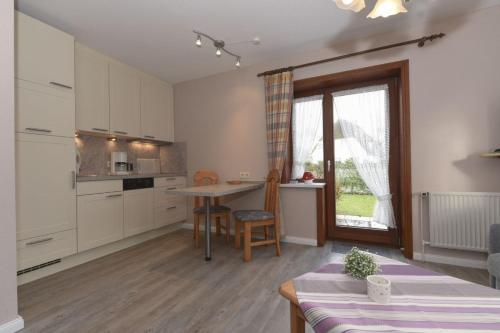 a kitchen with a table and a dining room at Schleswig-Holstein Whg 01 EG li in Nieblum