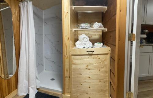 a bathroom with a shower and a wooden cabinet with towels at Sleepy Bear Cabin, Red River Gorge, KY, River Access & Views in Stanton
