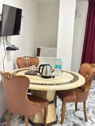 a table with chairs and a tea kettle on it at Hotel Safra in Chennai