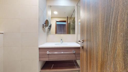 a bathroom with a sink and a mirror at Avani Palm View - Bright Two Bedroom with Sea View in Dubai
