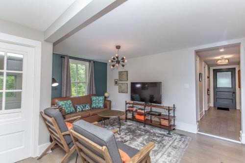 a living room with a couch and a tv at Boutique Quality Home Downtown by the Shaw in Niagara on the Lake