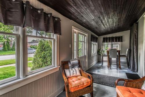 a screened in porch with chairs and windows at Boutique Quality Home Downtown by the Shaw in Niagara on the Lake