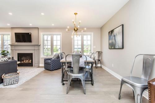 a dining room with a table and chairs and a fireplace at Boutique Quality in Old Towne with Hot Tub in Niagara on the Lake