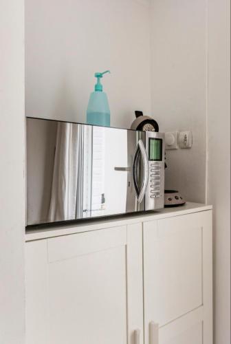 un miroir au-dessus d'un meuble blanc dans l'établissement Cocon et parking privé sur place a 5min de lille, à Mons-en-Baroeul