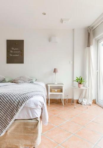 a white bedroom with a bed and a tiled floor at appartement cosy entier et parking privé sur place a 5min de lille et 10 min du Stade Pierre Mauroy in Mons-en-Baroeul