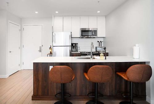 a kitchen with two bar stools and a counter at Exclusive 1BR Apt with NYC View in Hoboken