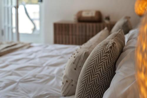 a bed with white sheets and pillows on it at Fire and Fun Luxe Stay w Pool Hot Tub and Game Room in Linden