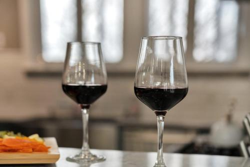 two glasses of red wine sitting on a counter at Fire and Fun Luxe Stay w Pool Hot Tub and Game Room in Linden
