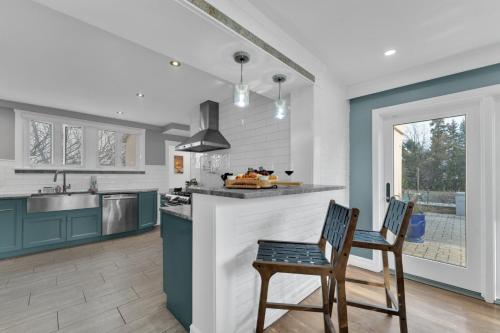 a kitchen with two chairs and a counter with a sink at Fire and Fun Luxe Stay w Pool Hot Tub and Game Room in Linden