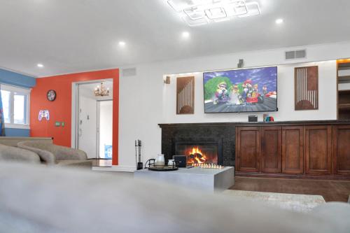 a living room with a fireplace and a flat screen tv at Fire and Fun Luxe Stay w Pool Hot Tub and Game Room in Linden