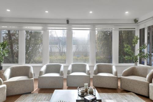 a living room with four chairs and windows at Fire and Fun Luxe Stay w Pool Hot Tub and Game Room in Linden