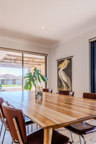 a dining room with a wooden table and chairs at Morning Light Beach House - by the BnB Collection in Albany