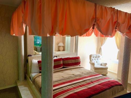 a bedroom with a bed with an orange canopy at Don Q Inn in Dodgeville