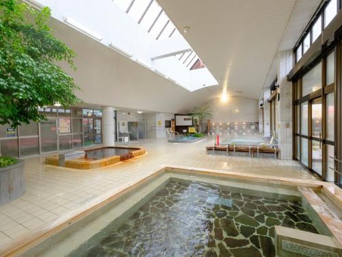 a large room with a pool of water in a building at Sagayamato Onsen Hotel Amandi in Saga