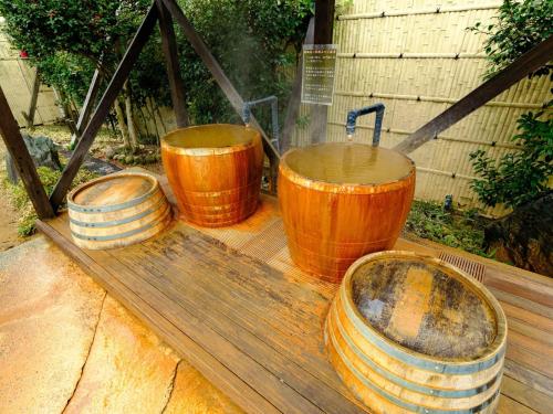 a group of three wooden buckets sitting on a table at Sagayamato Onsen Hotel Amandi in Saga