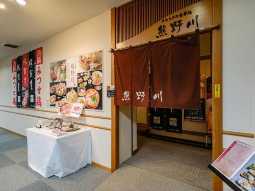 a room with a table and a sign on the wall at Sagayamato Onsen Hotel Amandi in Saga