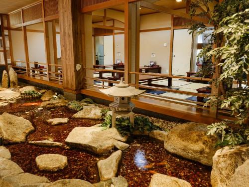 a building with a koi pond in the middle at Sagayamato Onsen Hotel Amandi in Saga