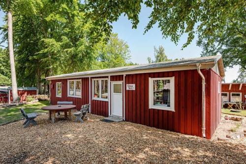 a red shed with a picnic table and a table at Dünenblick 2 in Ueckeritz