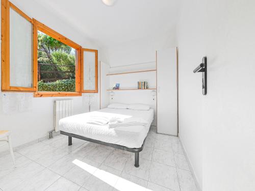 a white bedroom with a bed and a window at Appartements mit Veranda, Andora in Marina di Andora