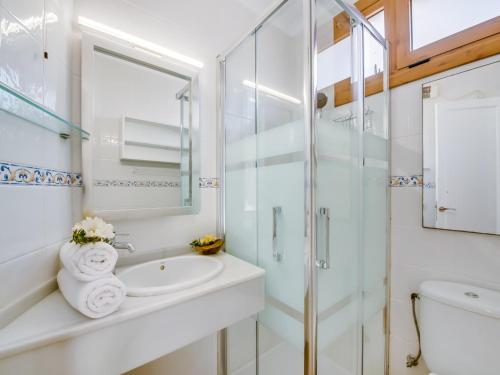 Un baño blanco con lavabo y ducha. en Apartment in Alcudia with Stunning Sea Views, en Alcudia
