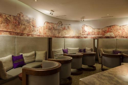 a restaurant with chairs and tables and a wall with maps at Intercontinental Real Guatemala by IHG in Guatemala