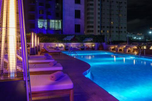 a swimming pool with lounge chairs and a hotel at night at Intercontinental Real Guatemala by IHG in Guatemala