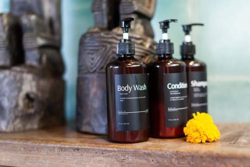 a group of three bottles on a wooden shelf at Darmada Eco Resort in Sidemen