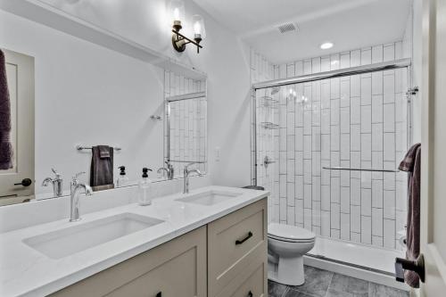 Un baño blanco con lavabo e inodoro. en Stunning 5 Star Stay! Guest Favorite with River View, en Saint Louis