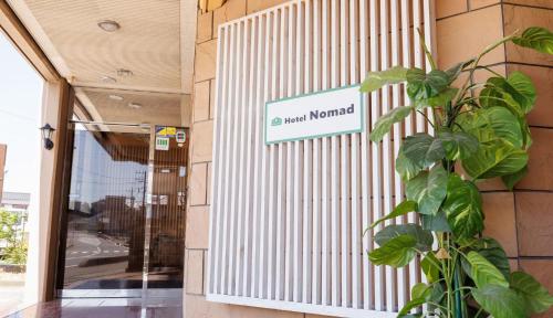 a sign on the side of a building with a plant at Hotel Nomad - Vacation STAY 74191v in Hitachi