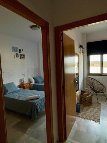 a bedroom with a bed and a door leading into a room at Apartamento en Barbate in Barbate
