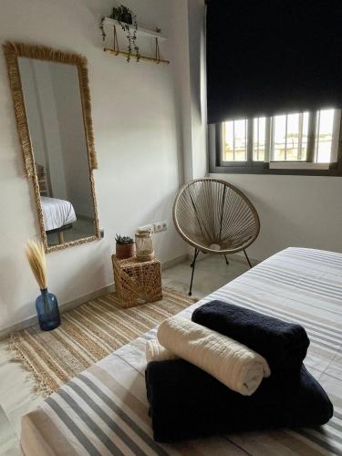 a bedroom with a bed and a mirror and a chair at Apartamento en Barbate in Barbate