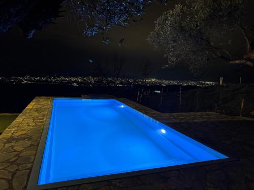 a blue pool with a view of the city at night at Villa Vista in Tirana
