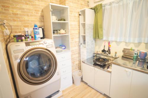 a kitchen with a washing machine in a kitchen at BlueHouse in Hiroshima