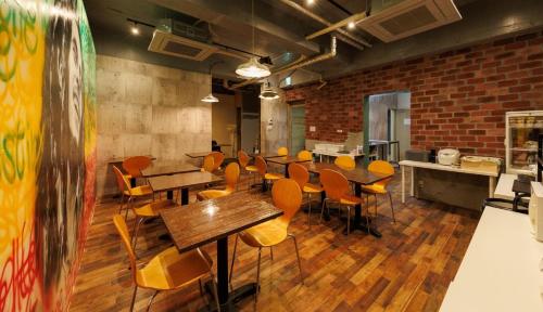 a dining room with tables and chairs and a brick wall at Hotel Nomad - Vacation STAY 73941v in Hitachi