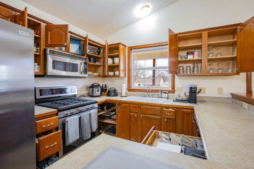 a kitchen with wooden cabinets and a stove top oven at Comfort Awaits at Cozy Get Away - Dog Friendly in Akron