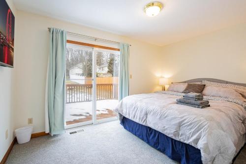 a bedroom with a bed and a sliding glass door at Comfort Awaits at Cozy Get Away - Dog Friendly in Akron