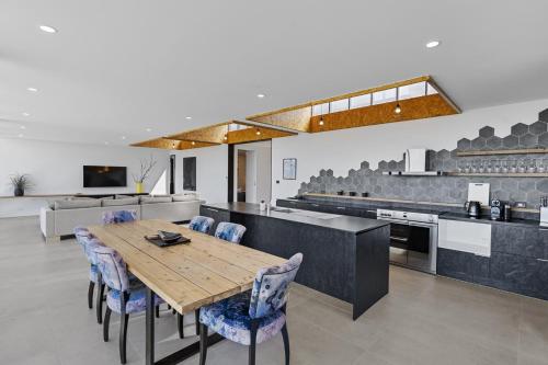 a large kitchen with a wooden table and chairs at Stylish Home with Outdoor Area & Spectacular Views in Penna