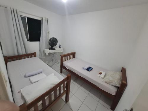 two beds in a small room with a window at Apartamento completo,no Janga, perto de Olinda in Paulista