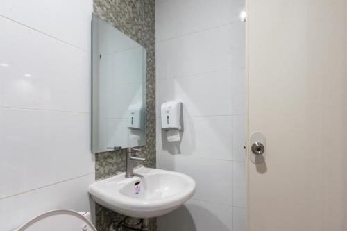 a white bathroom with a sink and a mirror at Hotel Sogo Santa Mesa in Manila