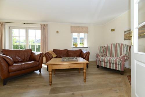 a living room with two couches and a coffee table at Haus Strandburg in Wyk auf Föhr
