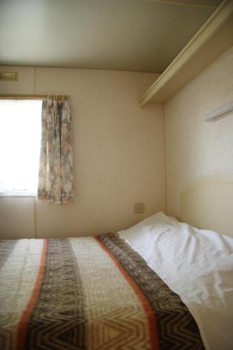 a small bedroom with a bed and a window at Camping Klaus in Cavallino-Treporti