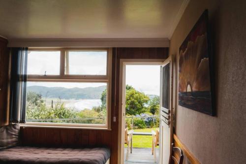 a room with a window with a bench and a view at Hicks Bay Lodge in Hicks Bay